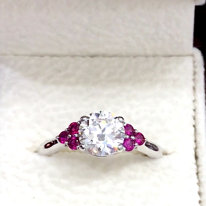 18kt White Gold Engagement Ring with 1.5 carat lab diamond at the center (Color: E | Clarity: VS1 | Round Cut). Three Natural Rubies on each side.
